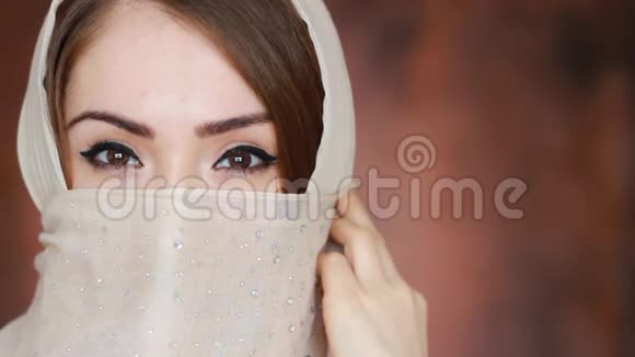 阿拉伯女人通过眼睛表达情感戴头巾的穆斯林女孩特写肖像视频的预览图