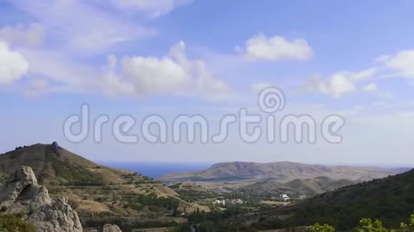 群山映衬蓝天白云蓝色的大海在山谷中的岩石之间海象云穿过视频的预览图