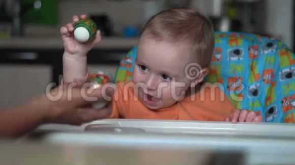 可爱的小宝宝用他母亲的手敲复活节彩蛋视频的预览图