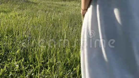 女人在清新的绿草中行走放松时间视频的预览图