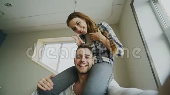 快乐的微笑和美丽的情侣在智能手机相机上自拍肖像而女孩坐在男人脖子上视频的预览图