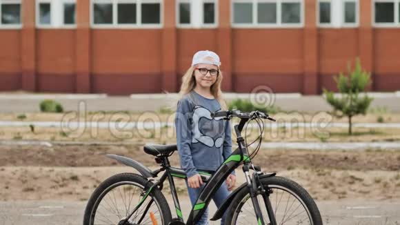 夏天金发小女孩在城里骑着自行车摆姿势视频的预览图