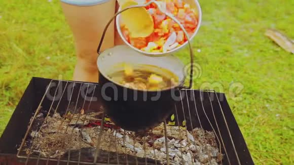 女人把蔬菜倒进保龄球在火上沸腾视频的预览图