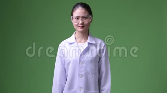 年轻漂亮的亚洲女医生戴着防护眼镜双臂交叉微笑视频的预览图