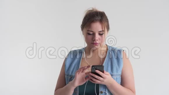 女性使用手机耳机听音乐视频的预览图