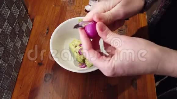 在家庭厨房的桌面上为鳄梨酱切洋葱视频的预览图