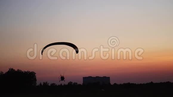 滑翔伞上的飞行员日落时降落在地上视频的预览图