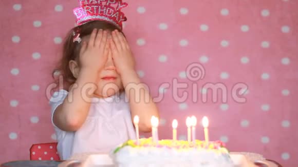 生日快乐孩子们在聚会上吹灭蛋糕上的蜡烛并许愿有趣的小女孩宝贝粉红色背景视频的预览图