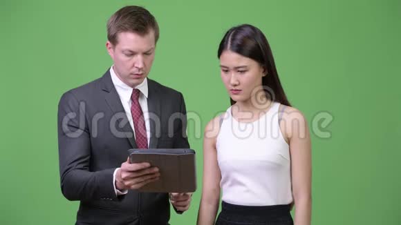 年轻的商人向年轻的亚洲商人展示坏消息视频的预览图