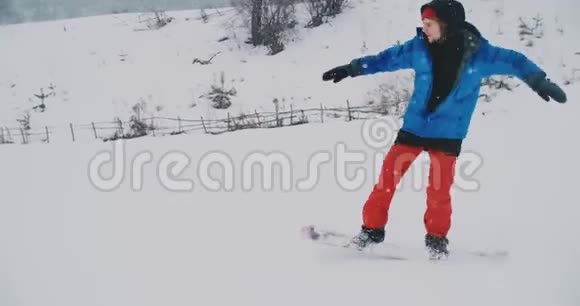 男性滑雪者骑在滑雪坡上的雪板上视频的预览图