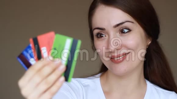 拿着信用卡微笑的年轻女子特写镜头信贷金融经济与购物的概念视频的预览图