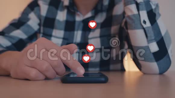 接近年轻人使用和玩智能手机与喜欢和爱的图标浮出智能手机视频的预览图
