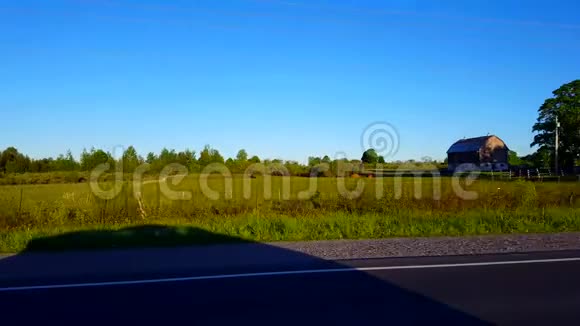 白天农村农场的侧视驾驶驾驶车辆驶过农村农场视频的预览图