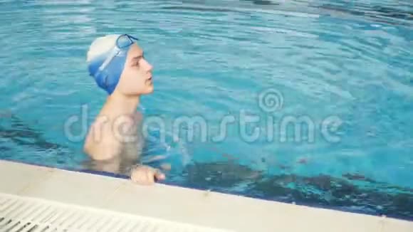 一个快乐的年轻人跳进水里在游泳池里训练的青少年视频的预览图