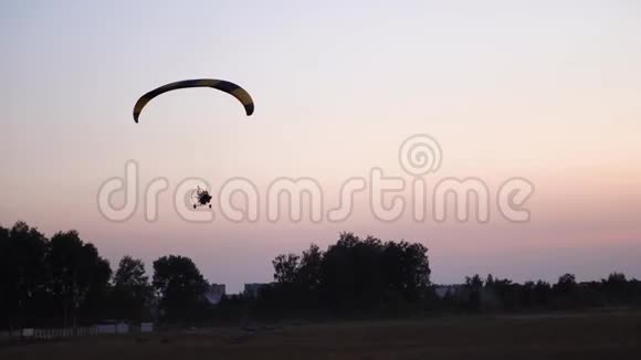 滑翔伞上的飞行员在天空中飞过日落和夜景背景视频的预览图