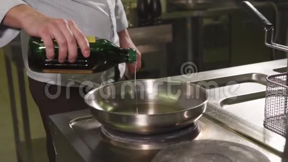 男性厨师在平底锅中加入油视频的预览图
