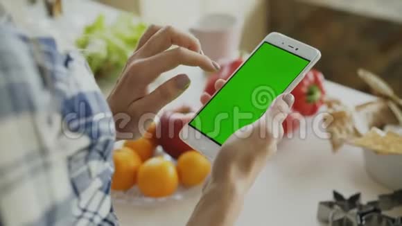 家厨房安装绿色屏幕的女性手游智能手机视频的预览图