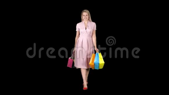 一个购物女人手里拿着购物走到镜头前阿尔法频道视频的预览图