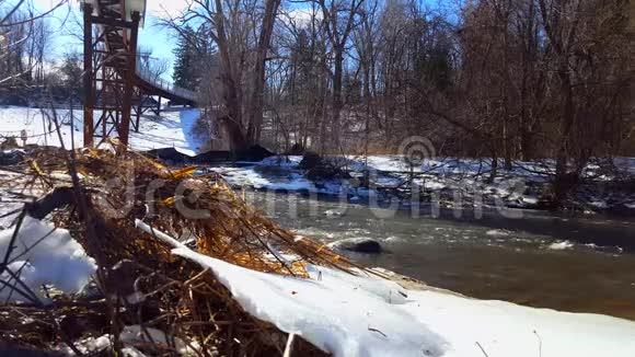 冬天的雪岸河雪道桥下冷水流视频的预览图
