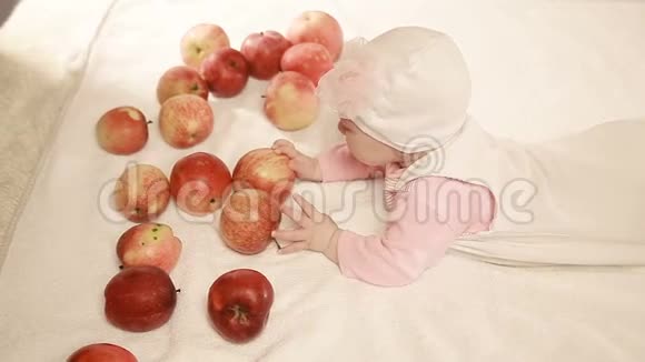 一个婴儿和一个苹果光背景上的孩子快乐的孩子视频的预览图