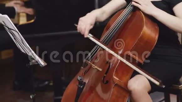 大提琴手大提琴手用弓演奏大提琴音乐台钢琴家视频的预览图