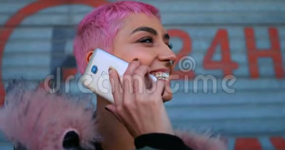 粉色头发的女人在店外的手机上聊天视频的预览图