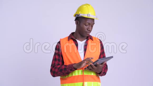年轻快乐的非洲男子建筑工人使用数字平板电脑视频的预览图