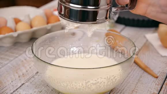 用手在玻璃碗中加入面粉作为蛋糕原料慢动作视频的预览图