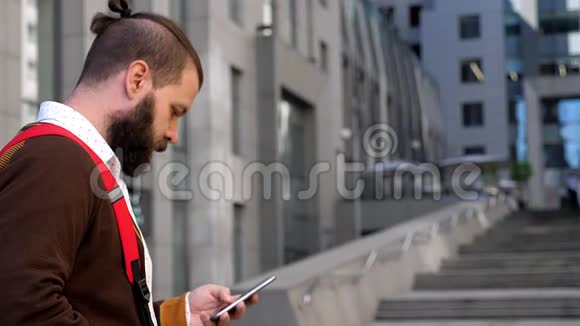 一个男人在手机屏幕上读信息移动互联网社交网络商务中心的商人胡子智能手机视频的预览图
