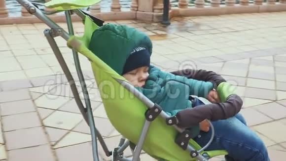 1岁的男婴睡在婴儿车里在旅途中睡着了视频的预览图