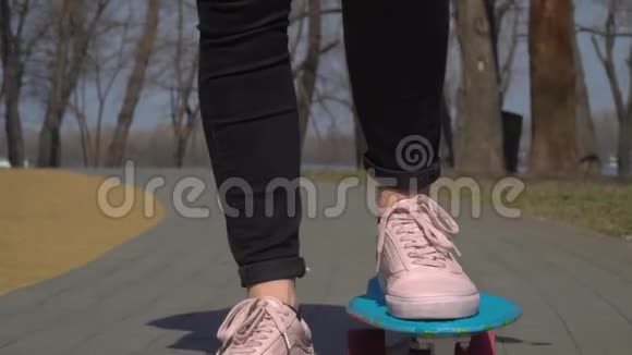 有滑板的时髦女孩用手机手拿棒棒糖视频的预览图