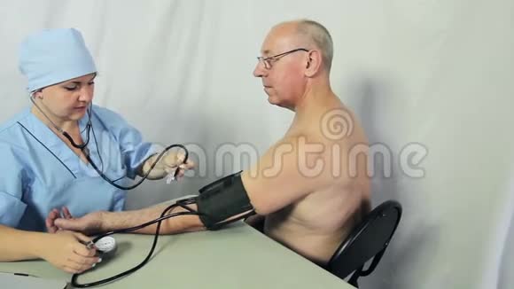 一位女医生坐在他的办公桌前测量病人的压力摄像机移动到杜莉视频的预览图