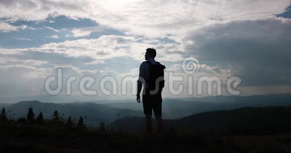 孤独地走在山里从后面看一个背着背包的人站在美丽的山景和视频的预览图