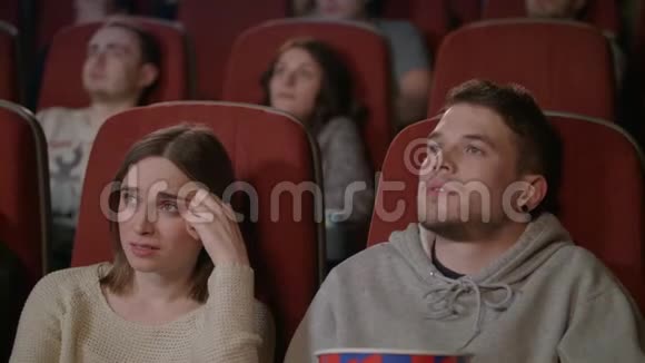 人们在电影院看恐怖电影年轻人洒爆米花视频的预览图