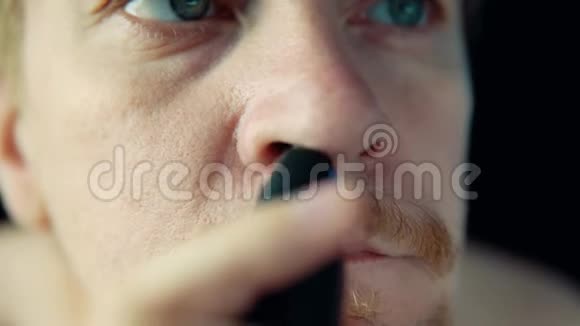 一个年轻人用电动修剪器从鼻子上去除头发视频的预览图