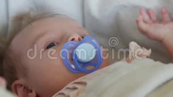 三个月的婴儿躺在毯子上用奶嘴宝宝脸贴紧视频的预览图