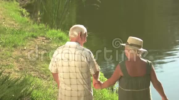 老年人在水边行走后景视频的预览图