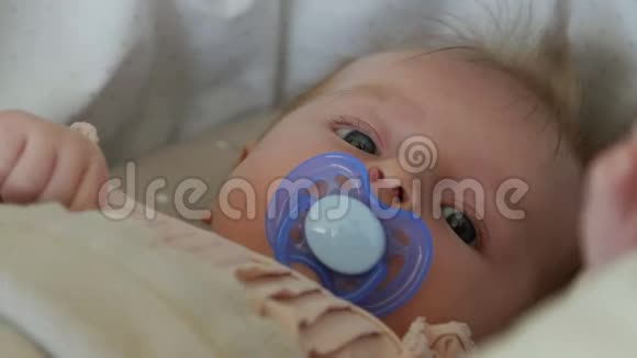 三个月的婴儿躺在毯子上用奶嘴宝宝脸贴紧视频的预览图