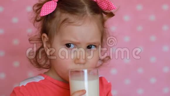 孩子不想喝牛奶抿了一口皱眉可爱的小女孩手里拿着一杯饮料视频的预览图