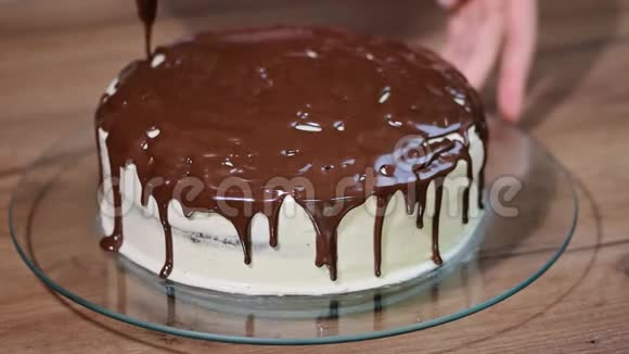 女人把融化的巧克力倒在巧克力蛋糕上视频的预览图