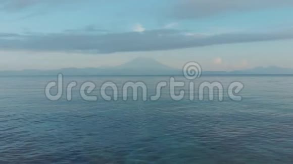 在火山阿贡的背景下无人机镜头低飞在海浪上巴厘岛印度尼西亚视频的预览图
