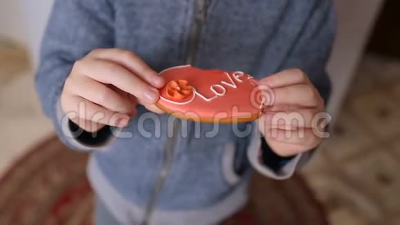 男孩吃着一个心形姜饼上面刻着爱铭文视频的预览图