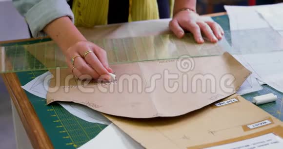 时装设计师在书桌4k处用棕色纸标记视频的预览图