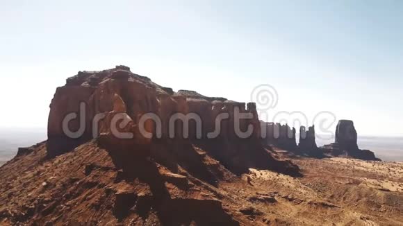 雄蜂在干砂岩沙漠上空右转靠近令人难以置信的红石山和纪念碑山谷的蓝天视频的预览图