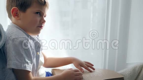 坐在窗台上用盲文书写盲童的手读视频的预览图