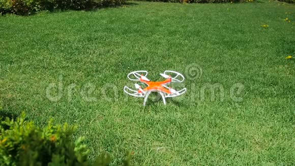 小玩具无人机在公园摘草的特写慢动作视频视频的预览图