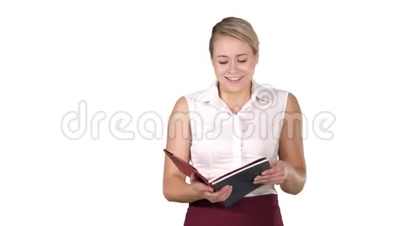 女人拿着打开书或笔记本在白色的背景上大声朗读一些东西视频的预览图