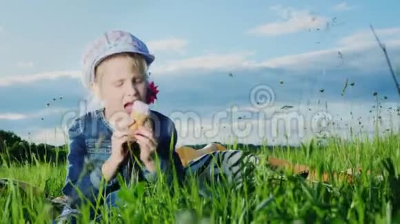 5岁的女孩在绿色草地上吃冰淇淋视频的预览图