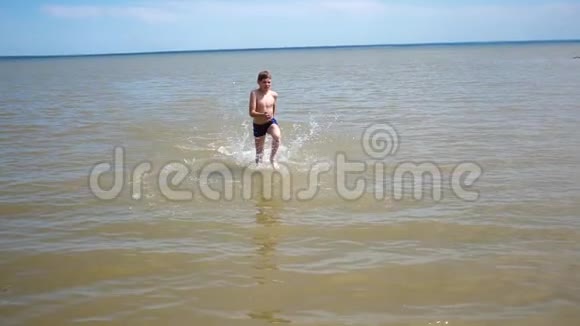 快乐的孩子在海滩上快乐地奔跑喷水夏日炎炎视频的预览图