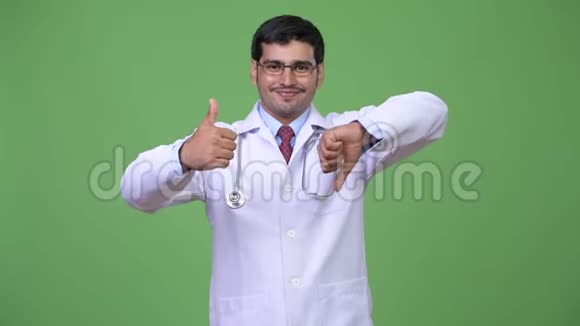 年轻英俊的波斯男医生在竖起大拇指和大拇指之间做出选择视频的预览图